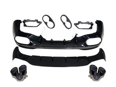A disassembled car body kit includes a black front bumper with vent openings, a lower splitter, light bezels, and dual exhaust tips, arranged on a plain white background.