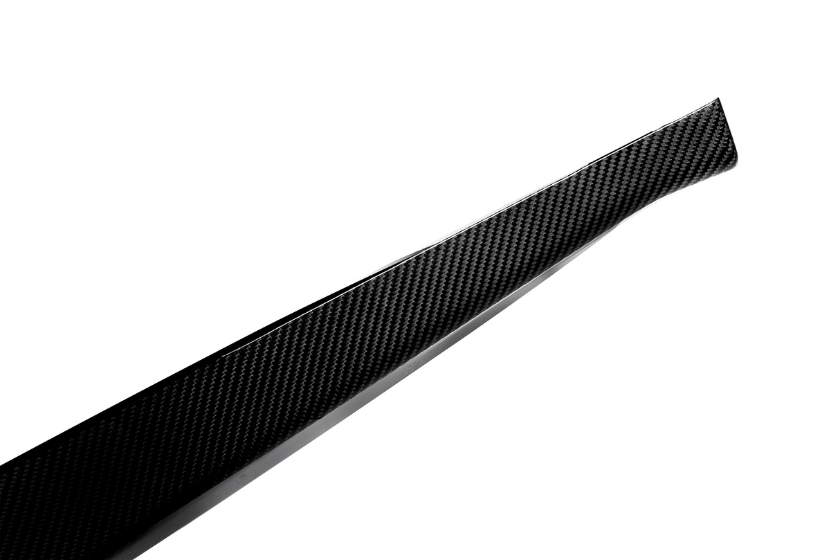A sleek, tapered piece of carbon fiber rests against a plain white background, showcasing its woven texture and glossy finish.