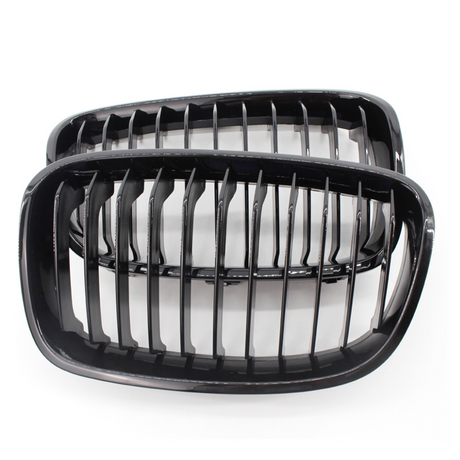 Two black kidney-shaped car grilles with vertical slats are positioned side by side, against a plain white background.