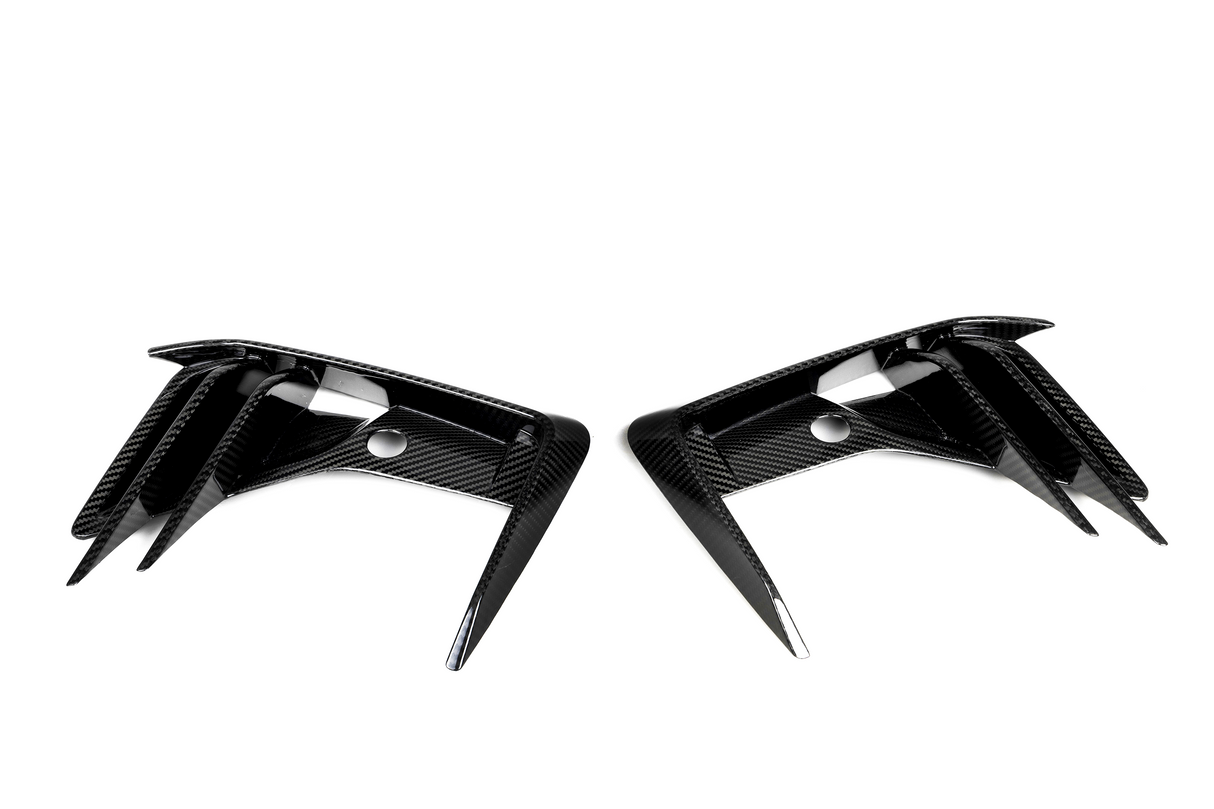 Two carbon-fiber air vents, placed symmetrically, have angular, aerodynamic fins against a plain white background.