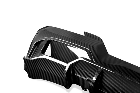 A sleek carbon fiber car part with a glossy finish, featuring angular sections and cutouts, set against a plain white background.