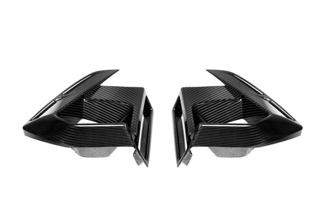 Two symmetrical, black carbon fiber air vents with sharp angles, facing each other, against a plain white background.