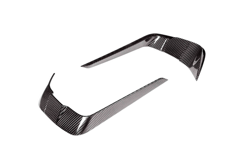 Two curved carbon fiber trim pieces, reflecting light, positioned apart on a white background. They are designed for vehicle detailing.