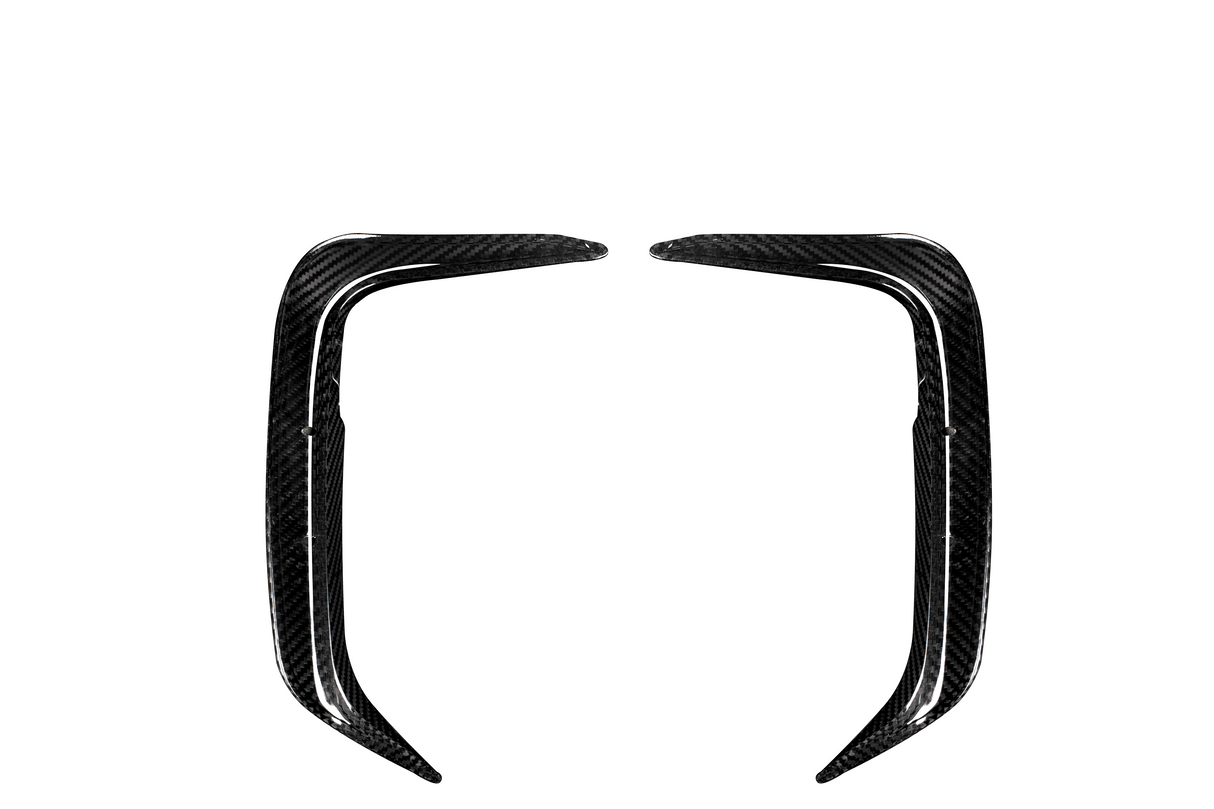 Two elongated, curved carbon fiber components face each other symmetrically on a plain white background, resembling aerodynamic car parts or trim pieces.