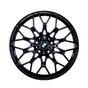 A black, multi-spoke alloy wheel with a central BMW logo, displayed against a plain white background, showcasing intricate design and structure.