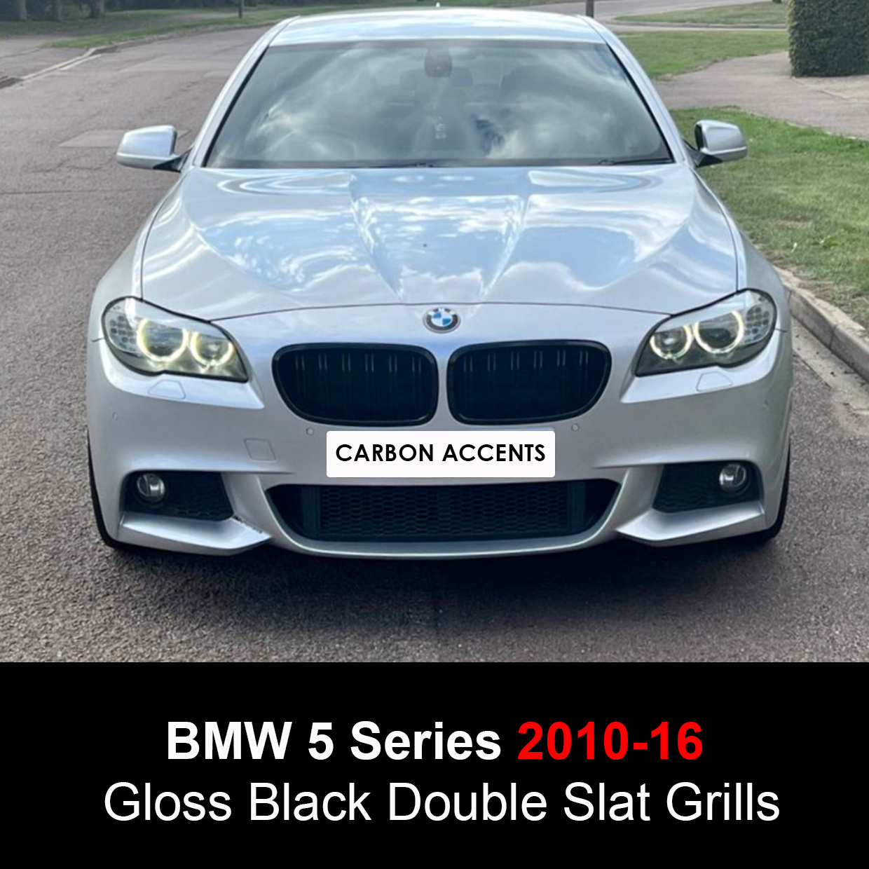 A BMW 5 Series car with illuminated headlights is parked on a street. The front grille features "Carbon Accents." Text reads: "BMW 5 Series 2010-16 Gloss Black Double Slat Grills."