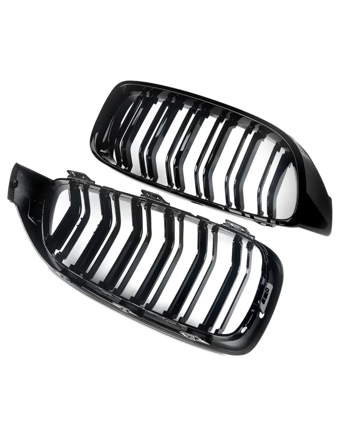 Two black, glossy car grilles with vertical slats are positioned side by side against a white background, showing their shiny surfaces and curved design.
