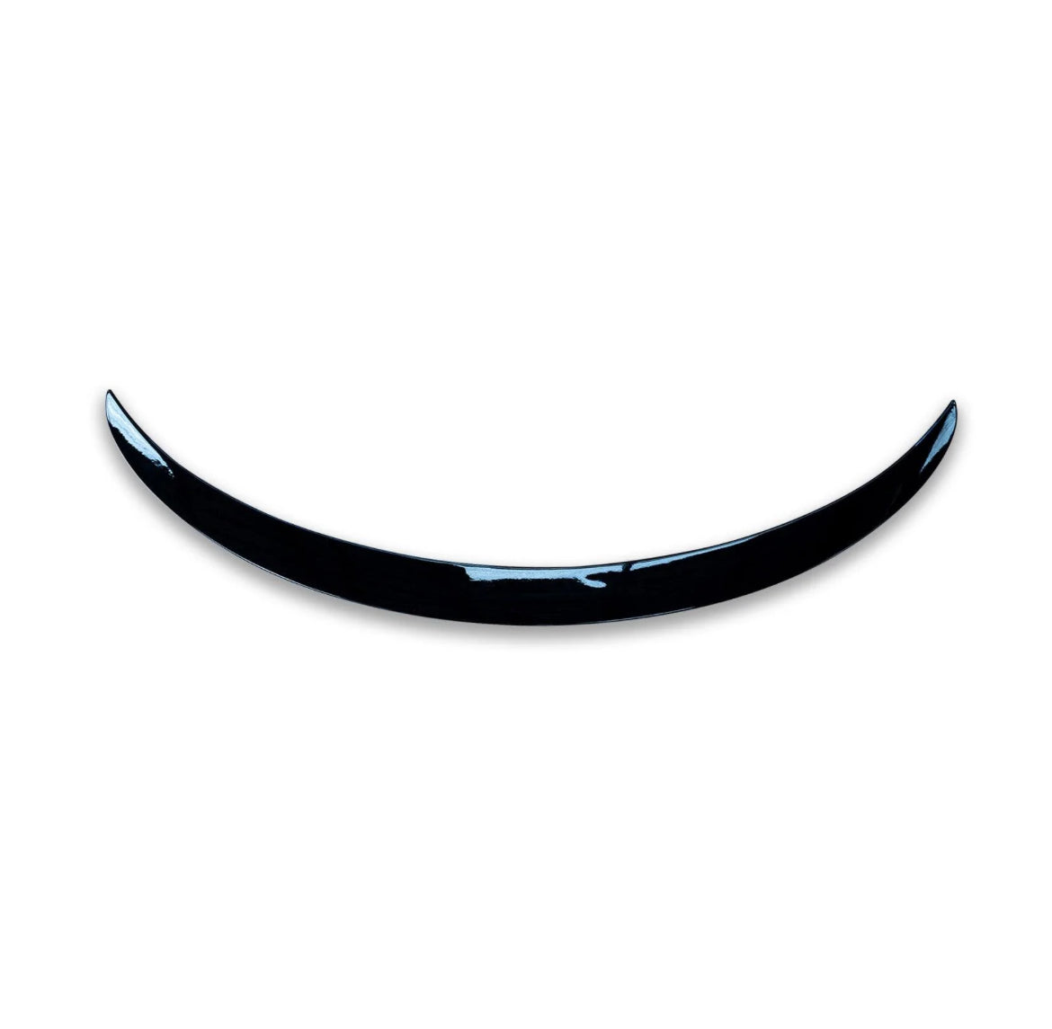 A shiny, curved black object resembling a crescent is positioned against a plain white background, giving a minimalist and modern appearance.