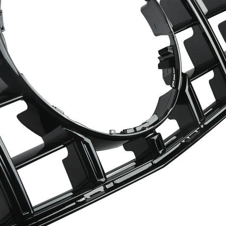 The image features a glossy black plastic car grille with a prominent circular opening, showcasing a grid pattern and intricate detailing, suggesting it is part of a vehicle's front design.
