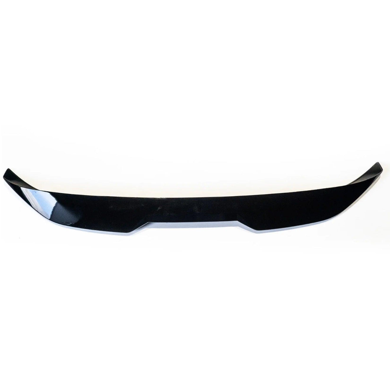 Black, glossy car spoiler positioned horizontally, featuring a slightly curved shape with angular edges, set against a plain white background.