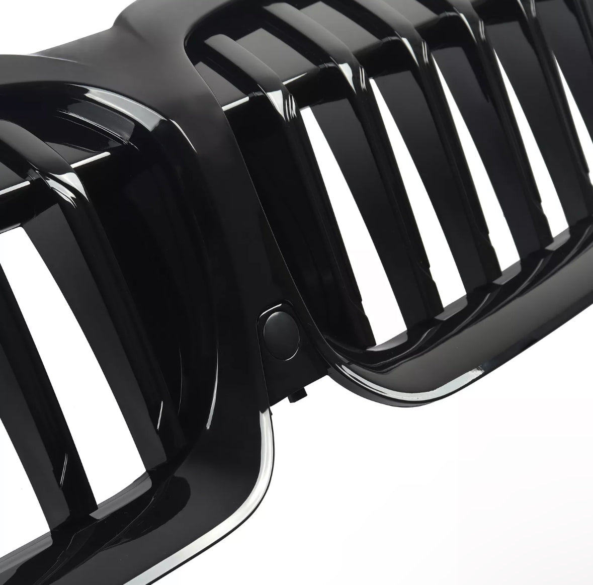 A black, glossy car grille with vertical slats is shown in close-up detail. The grille's shiny surface and precise design indicate a high-quality automotive component.