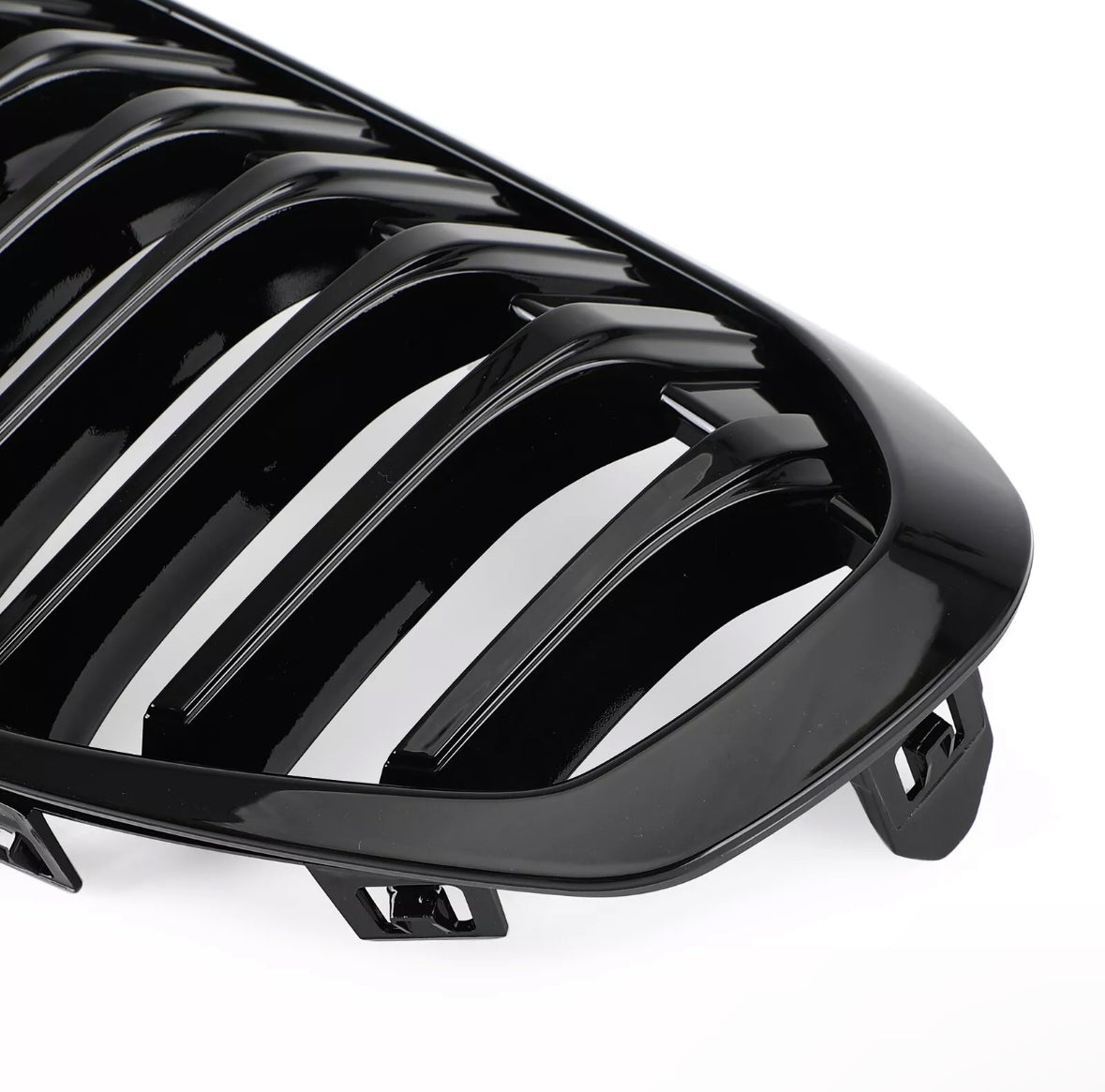 A glossy black car grille with multiple vertical slats is positioned against a plain white background, highlighting its sleek design and curved edges.