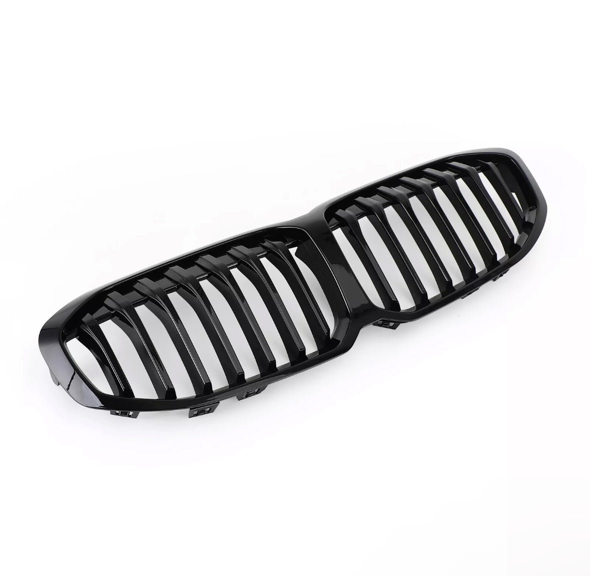 A glossy black car grille, featuring vertical slats, rests on a white background, designed for vehicle front-end styling and air flow.
