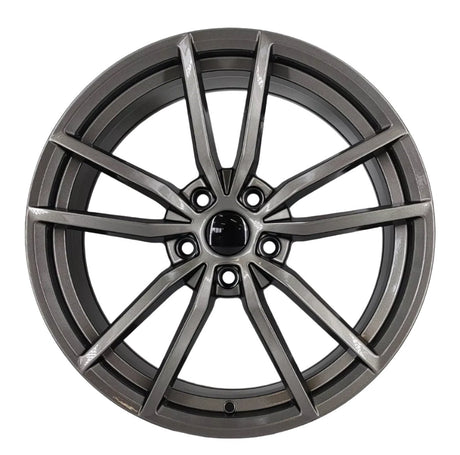 A metallic alloy wheel with intricate spoke design is centered on a plain white background, displaying a modern, sleek appearance, highlighting its detailed craftsmanship and shiny finish.