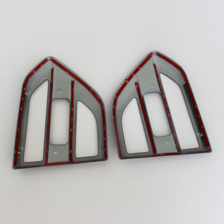 Two plastic frames, shaped like arrowheads, are placed side by side on a white background. Each frame is grey with red lining and features numbered notches along the edges.