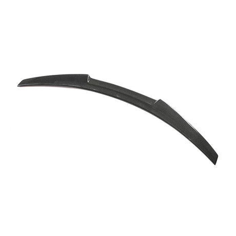 A curved carbon fiber automotive spoiler rests on a white background, featuring a sleek design with diagonal patterns and a raised middle section.