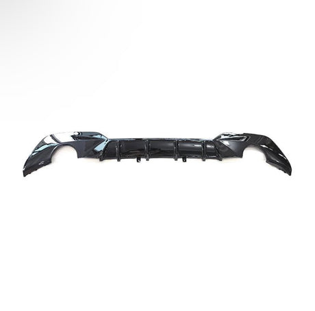 A black car bumper is laid against a plain white background, showcasing its aerodynamic design with curved edges and integrated vent-like features.