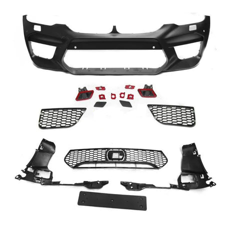 Assorted black car bumper parts, including a large bumper frame and multiple grilles, lay arranged on a white surface, showcasing components typically used in vehicle front-end assembly.
