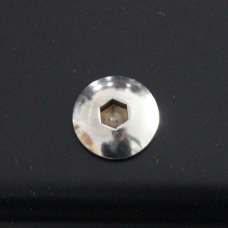 A metallic hex socket screw head embedded in a smooth, dark surface, reflecting light. The background is glossy, enhancing the screw's shiny appearance.