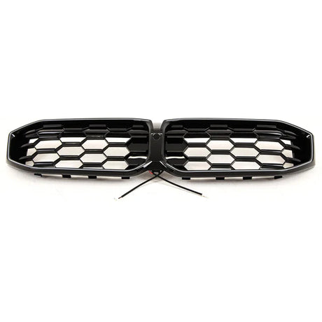 A hexagonal-patterned car grille with black finish, featuring a central wiring connection, is positioned on a plain white background.