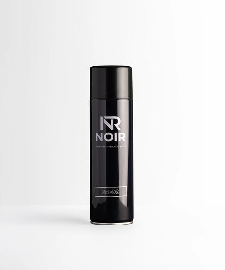 A black cylindrical deodorant can labeled "NR NOIR HIGH PRESSURED DEODORISER CREDO" stands upright, centered on a smooth white surface against a light gray background.