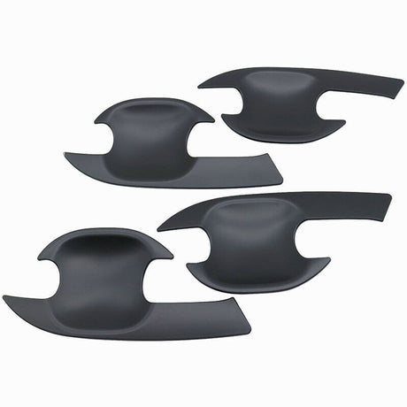 Four black, curved plastic door handle covers are arranged on a plain white background. Each cover features a cutout design, tailored to fit vehicle door handles.