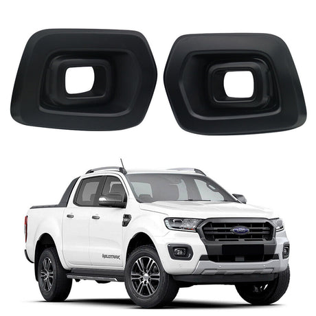 Two black plastic fog light covers are displayed above a white pickup truck with a modern design, parked on a plain white background.