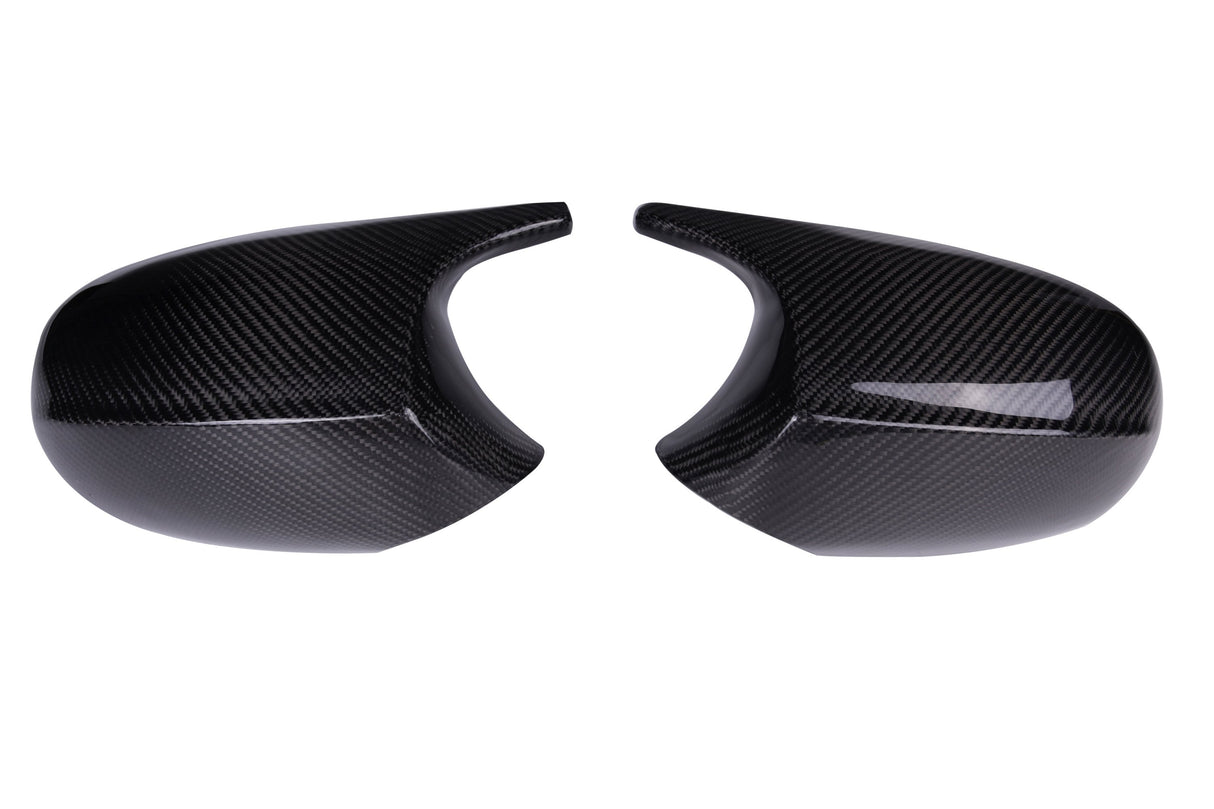 Two glossy carbon fiber mirror covers facing each other, exhibiting curved shapes and smooth surfaces, set against a plain white background.