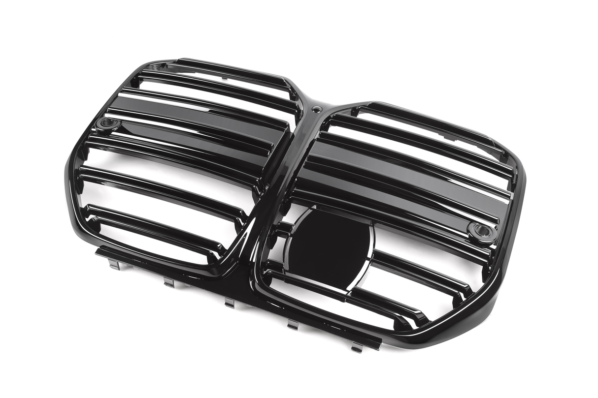 A glossy black automobile grille with horizontal slats, featuring two side-by-side sections and a central emblem space, is positioned against a plain white background.