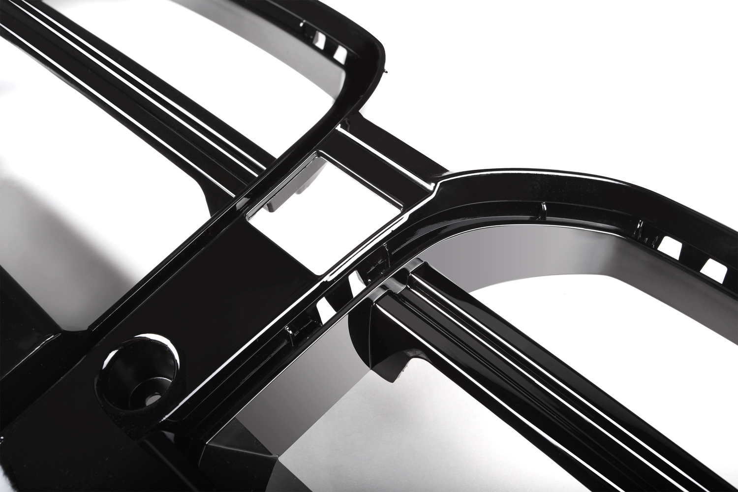 Shiny black plastic frame with curved edges intersecting at right angles, placed on a reflective white surface.