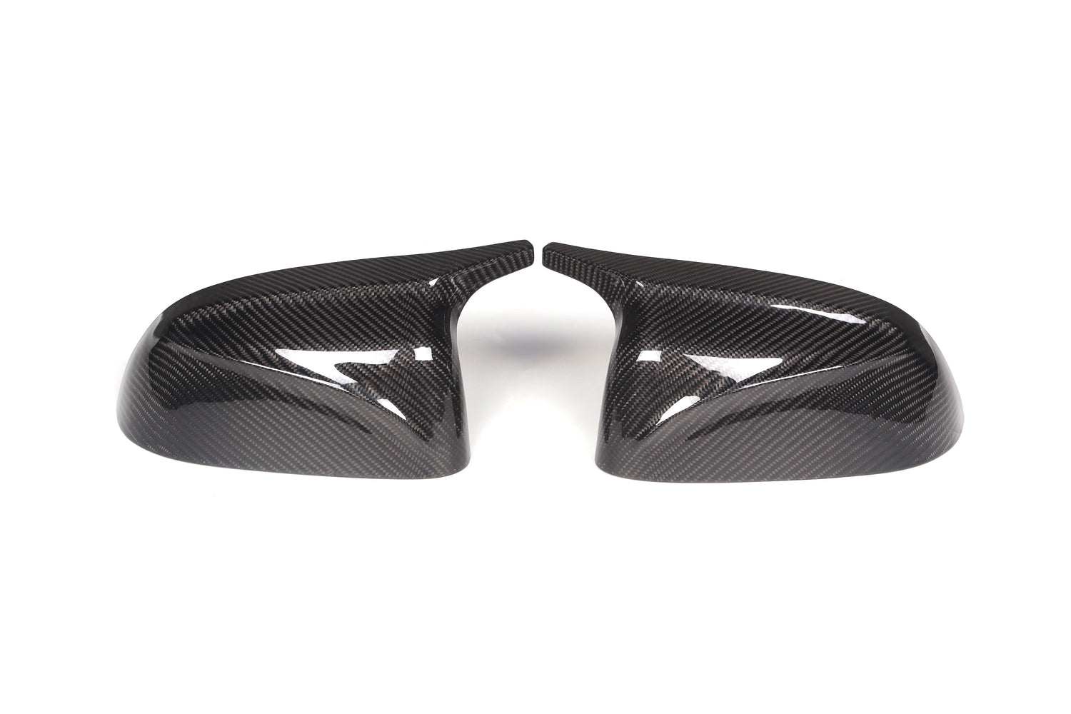 Two carbon fiber side mirror covers are positioned side by side, slightly angled inward, on a plain white background, showcasing their glossy, textured surfaces.