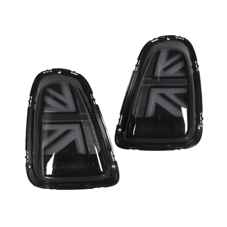 Two black car taillights with arrow-shaped patterns are positioned side by side, facing forward, against a white background, showcasing their glossy finish and angular design.