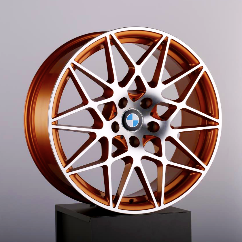 A copper-colored alloy wheel with a complex, multi-spoke design rests on a black pedestal. The BMW logo is in the center. The background is a plain light gray.