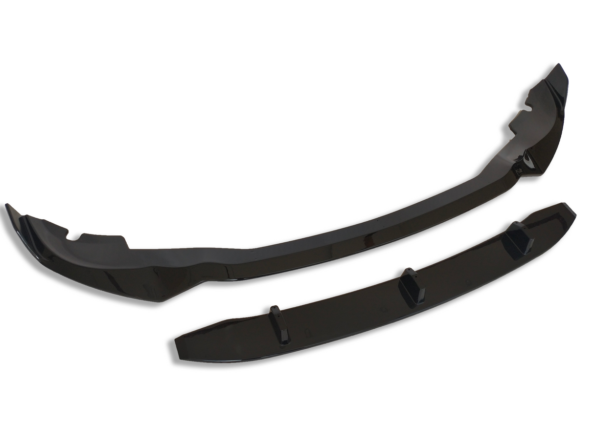 A pair of glossy black car lip spoilers lie side by side against a plain white background. The larger piece is curved, while the smaller piece is straighter with small protrusions.