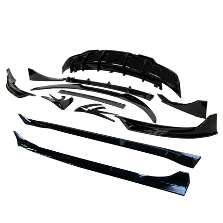 Black car body kit components are arranged neatly on a white background, including a front splitter, side skirts, and fender flares, displaying their glossy finish and aerodynamic design.