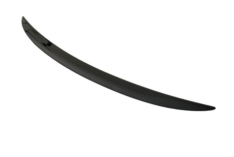 A sleek, black car spoiler lies on a plain white surface, curving slightly upward at the ends.
