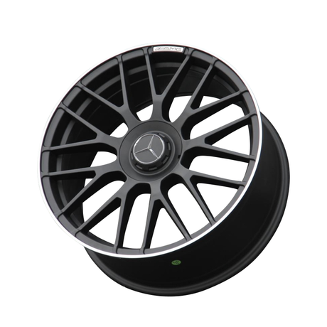 A black alloy car wheel with a multi-spoke design features a central emblem, the Mercedes-Benz logo. "AMG" is inscribed on its rim. The background is plain white.