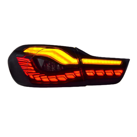 A car tail light features illuminated red and amber LED segments arranged in a modern, angular design, set against a black background.