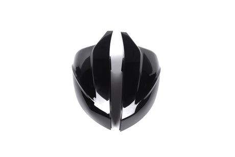 A shiny, black, futuristic helmet with sleek, curved shapes is split down the middle, placed against a plain white background.