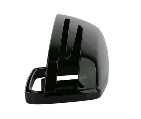 A glossy black, curved plastic object with slots, resembling a vehicle side mirror cover, sits isolated against a plain white background. No text is present.