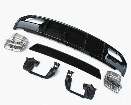 Car bumper components lie on a plain white surface, including black plastic and metallic parts arranged separately, showcasing a disassembled view typical for repairs or upgrades.