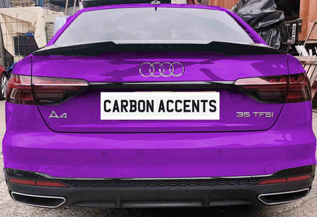 A purple Audi A4 with "35 TFSI" badge is parked, displaying the license plate text "CARBON ACCENTS." The vehicle is in a workshop area with various items in the background.