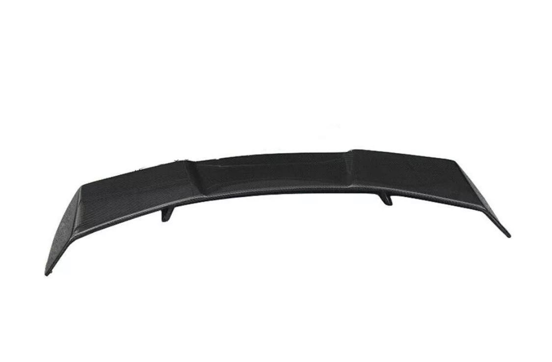A black car spoiler slightly curved upwards, positioned on a plain white background. The surface has a textured pattern, indicating a potential carbon fiber material.
