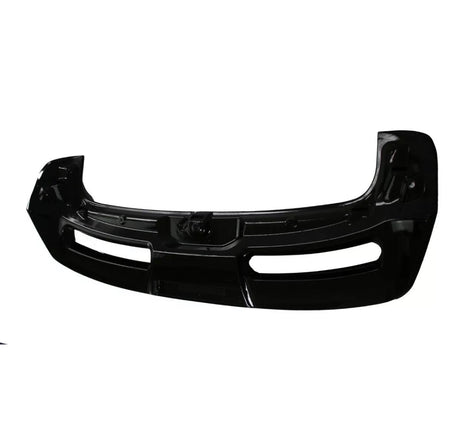 A black car bumper, featuring two large air vents, lies against a plain white background, highlighting its sleek, curved design.