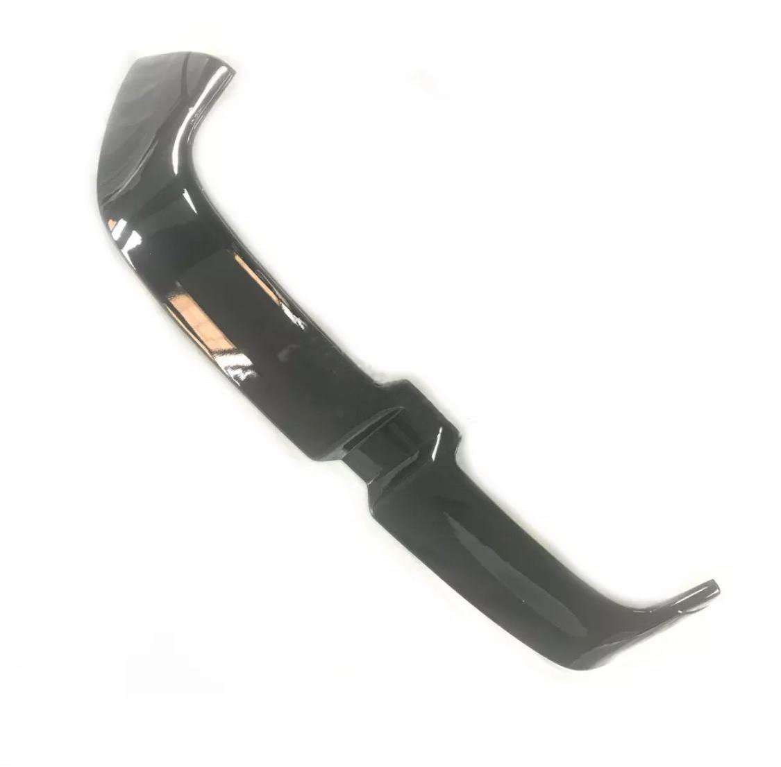A glossy black car spoiler with an angular design rests on a plain white background.