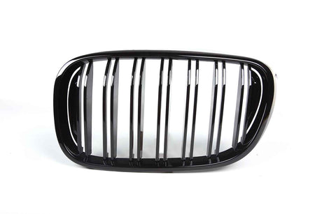 A shiny black car grille features vertical slats framed by an oval shape, set against a plain white background.