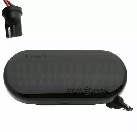 An oval black car side marker light labeled "12V5W CE SM1 06 (E9) 22974," with a socket and exposed wiring, set against a plain background.