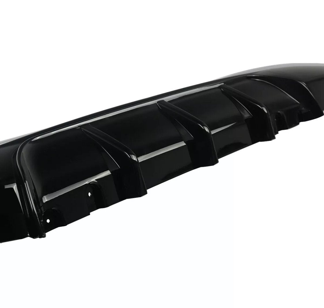 A black car bumper features multiple vertical fins, designed for aerodynamics, set against a plain white background.