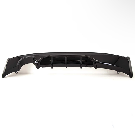 A glossy black car bumper with aerodynamic fins is resting on a plain white background, showcasing its sleek design and contours.