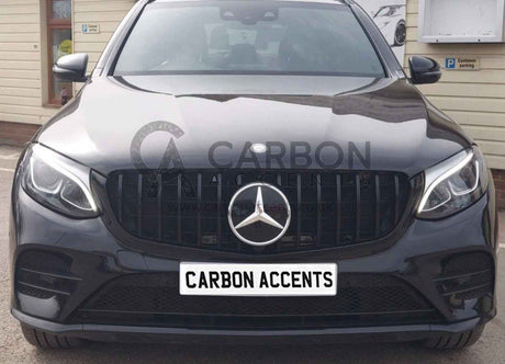 A black Mercedes-Benz car is parked outside a beige building, displaying the text "CARBON ACCENTS" on a white license plate. A small sign indicates "Customer parking" nearby.